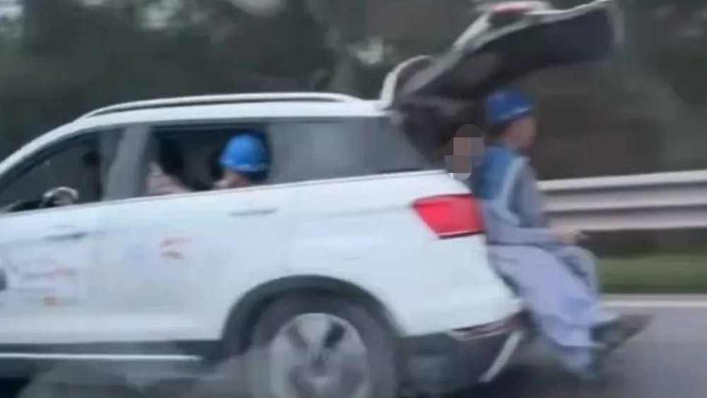 又见行驶中车辆后备厢打开坐人！疑似车内满员，多出2人后备厢内“加座”
